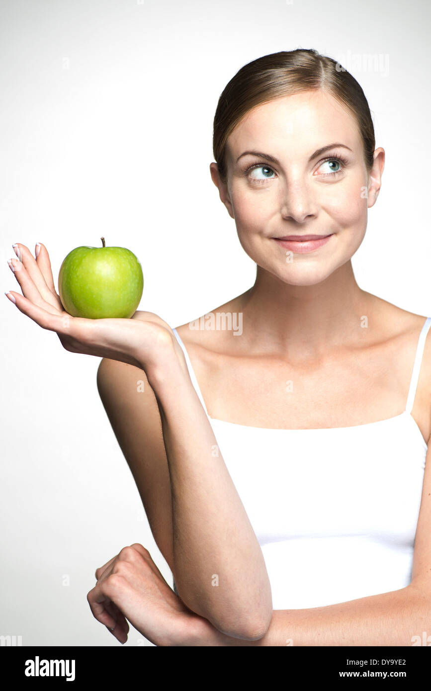 Young woman holding up green apple Stock Photo
