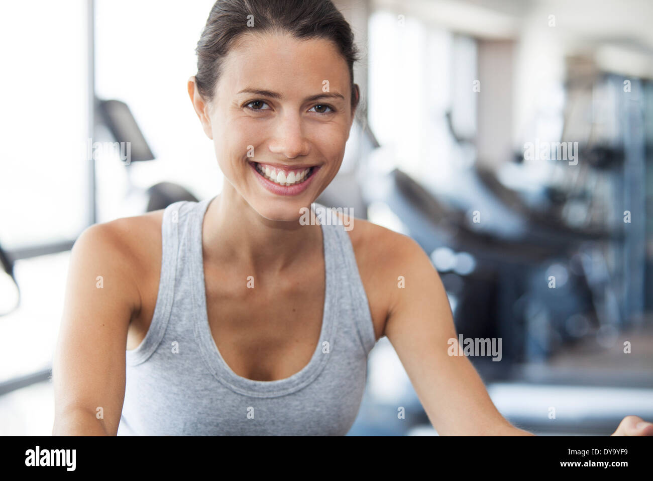 Young woman using exercise machine at gym Stock Photo - Alamy