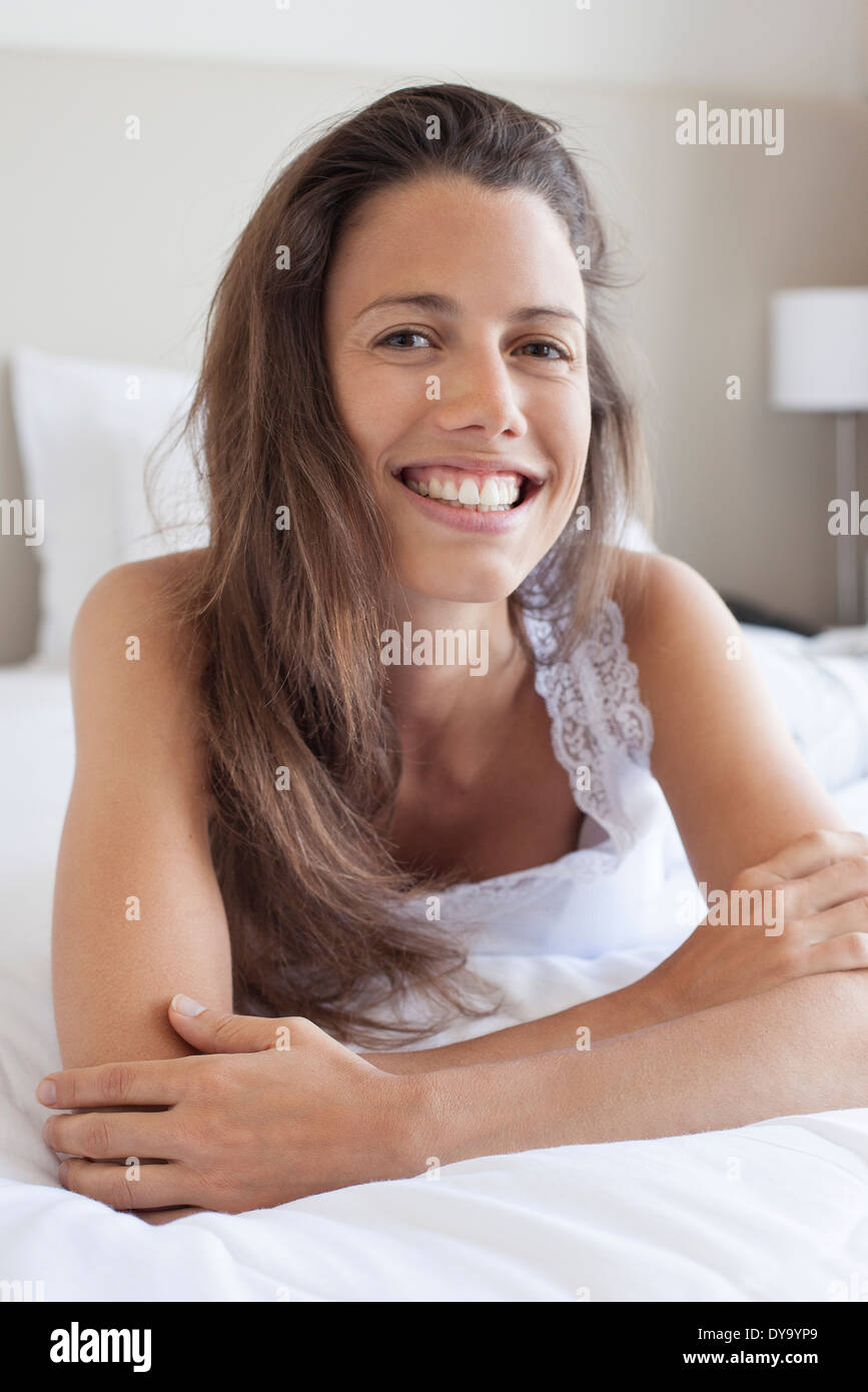 Young woman lying on stomach, leaning on elbow, portrait Stock Photo