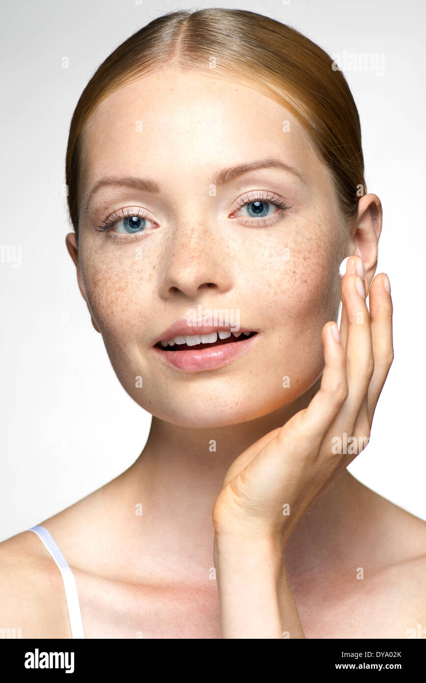 Young woman applying moisturizer to face Stock Photo Alamy