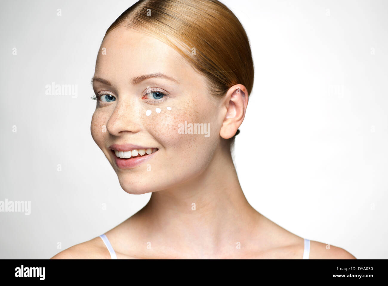 Young woman applying undereye cream Stock Photo