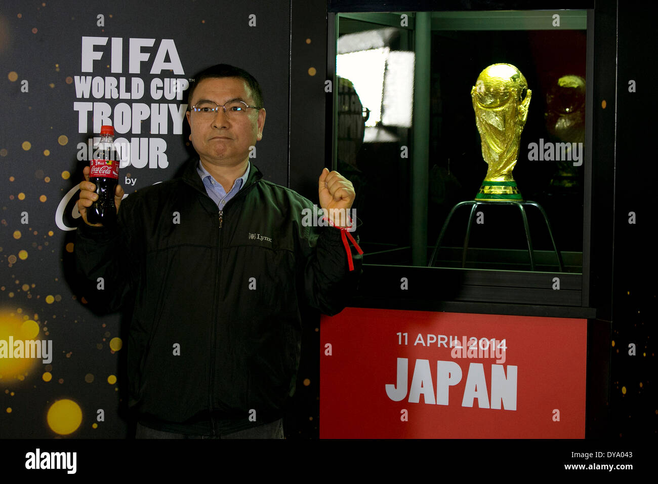 Tokyo, Japan. 11th Apr, 2014. A visitor poses for the cameras next to the World Cup trophy during the 'Coca Cola Cup Trophy' event in Shibuya, on April 11, 2014. The tour will be release in Tokyo and Rikuzentakata Tohoku on April 12 under the theme 'Tournament Everyone Lead' to send the spirit to the world from the Northeast Japan. Credit:  Rodrigo Reyes Marin/AFLO/Alamy Live News Stock Photo
