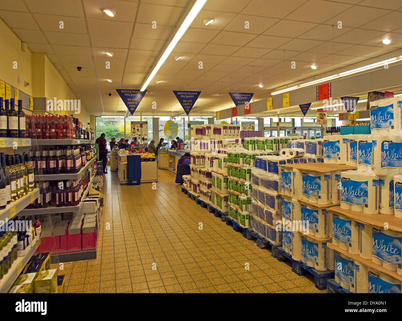 pallets of toilet paper and kitchen towels and shelves of reasonably priced wine towards the check out area Stock Photo