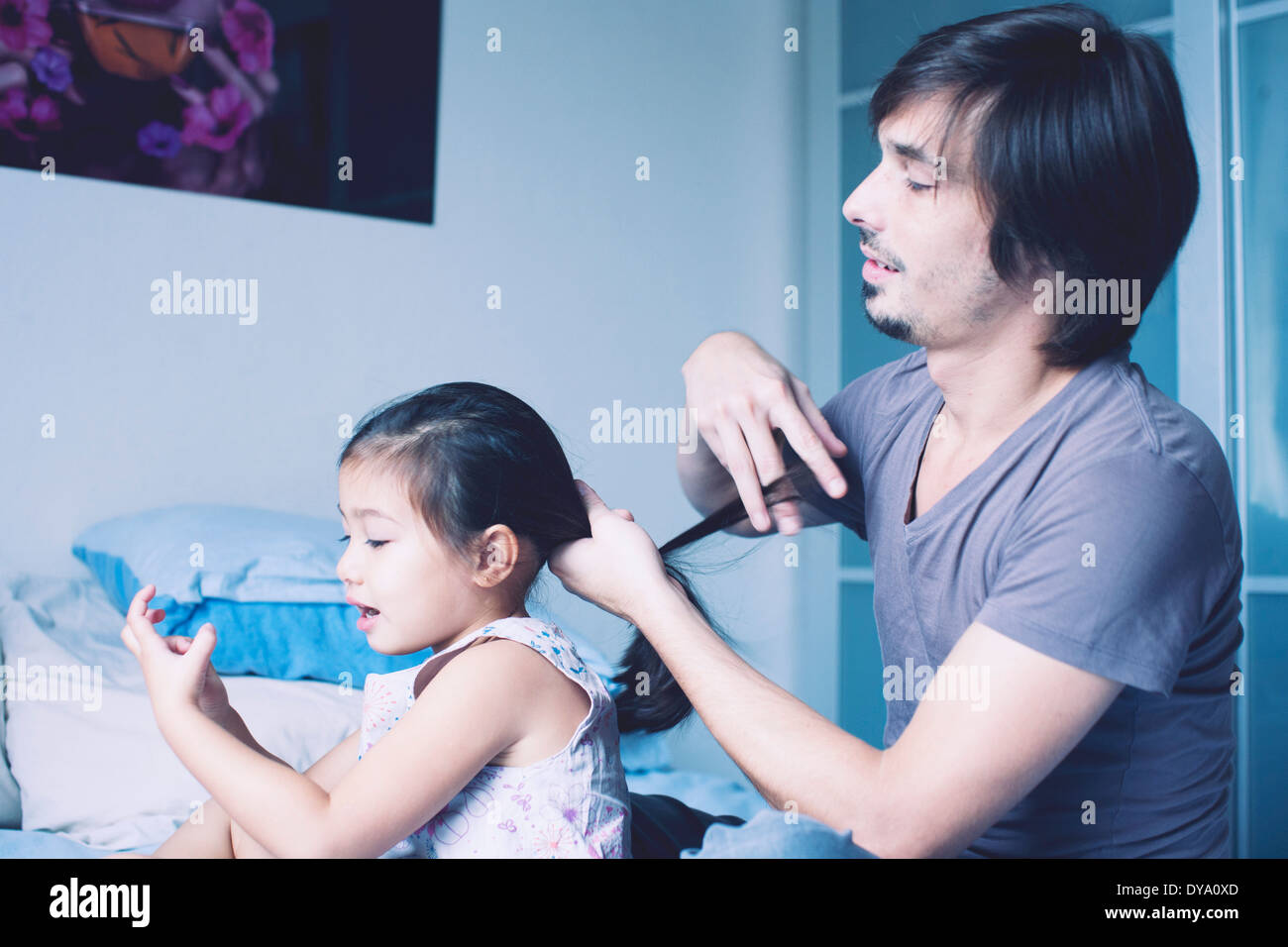 Father putting daughter's hair in ponytail Stock Photo