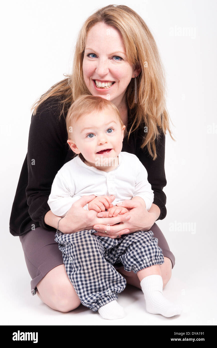Mother holding baby boy on lap, studio portrait Stock Photo
