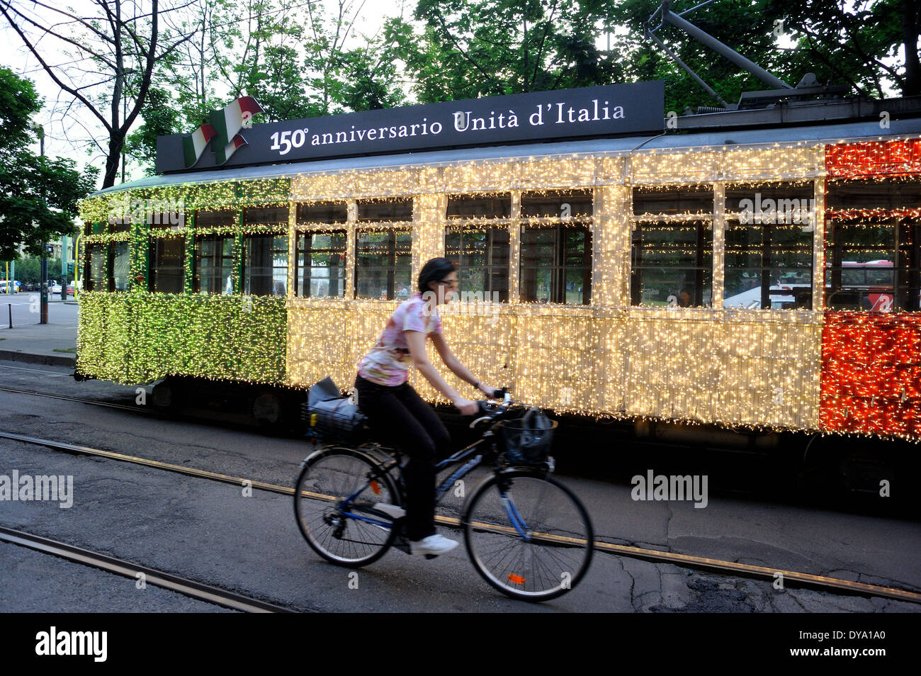 National flags of Italy adorn  streetcar on downtown Milan streets. (150 th anniversary of Italy Unity). Stock Photo