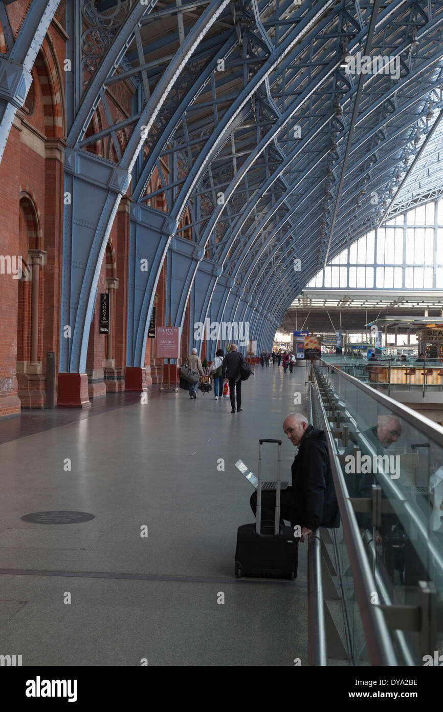 A businessman works on his laptop at St. Pancras station in London, England Stock Photo