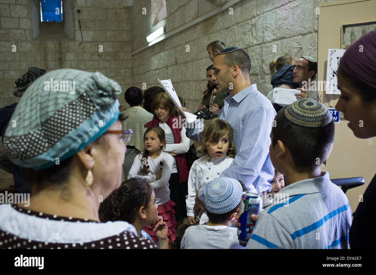 A family performs a Halaqah (Sephardic Jews) or Upsherin (Ashkenazi Jews) ceremony at the tomb of the Prophet Samuel, cutting their three-year-old son's hair for the first time. This is the traditional burial site of the biblical Prophet Samuel, just north of Jerusalem. The tomb is located in an underground chamber inside a small synagogue in the 18th century Nabi Samwil Mosque, built on the remains of a Crusader-era fortress. Stock Photo