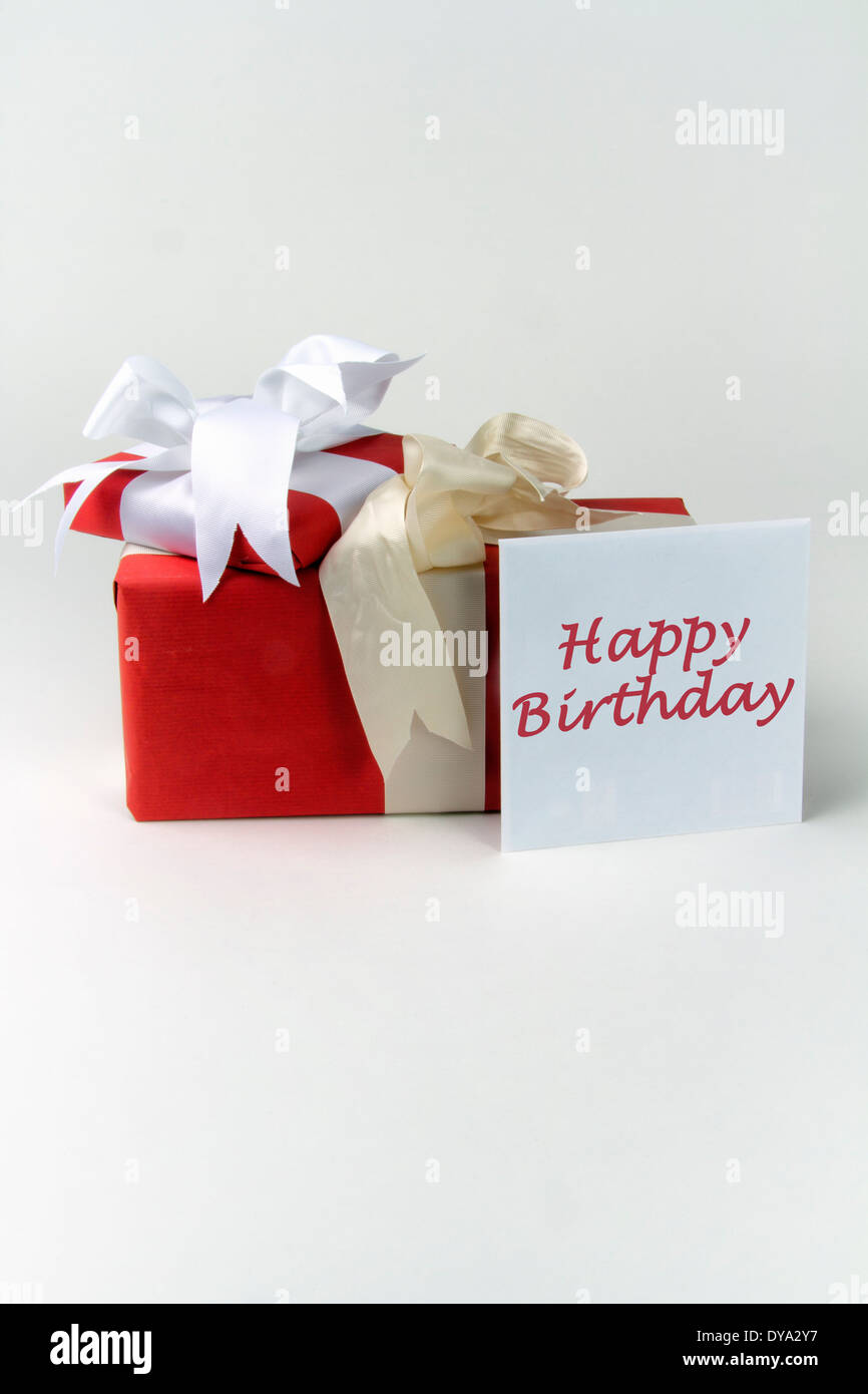 Two gift wrapped presents with bows plus a greeting card in an envelope with the message Happy Birthday Stock Photo