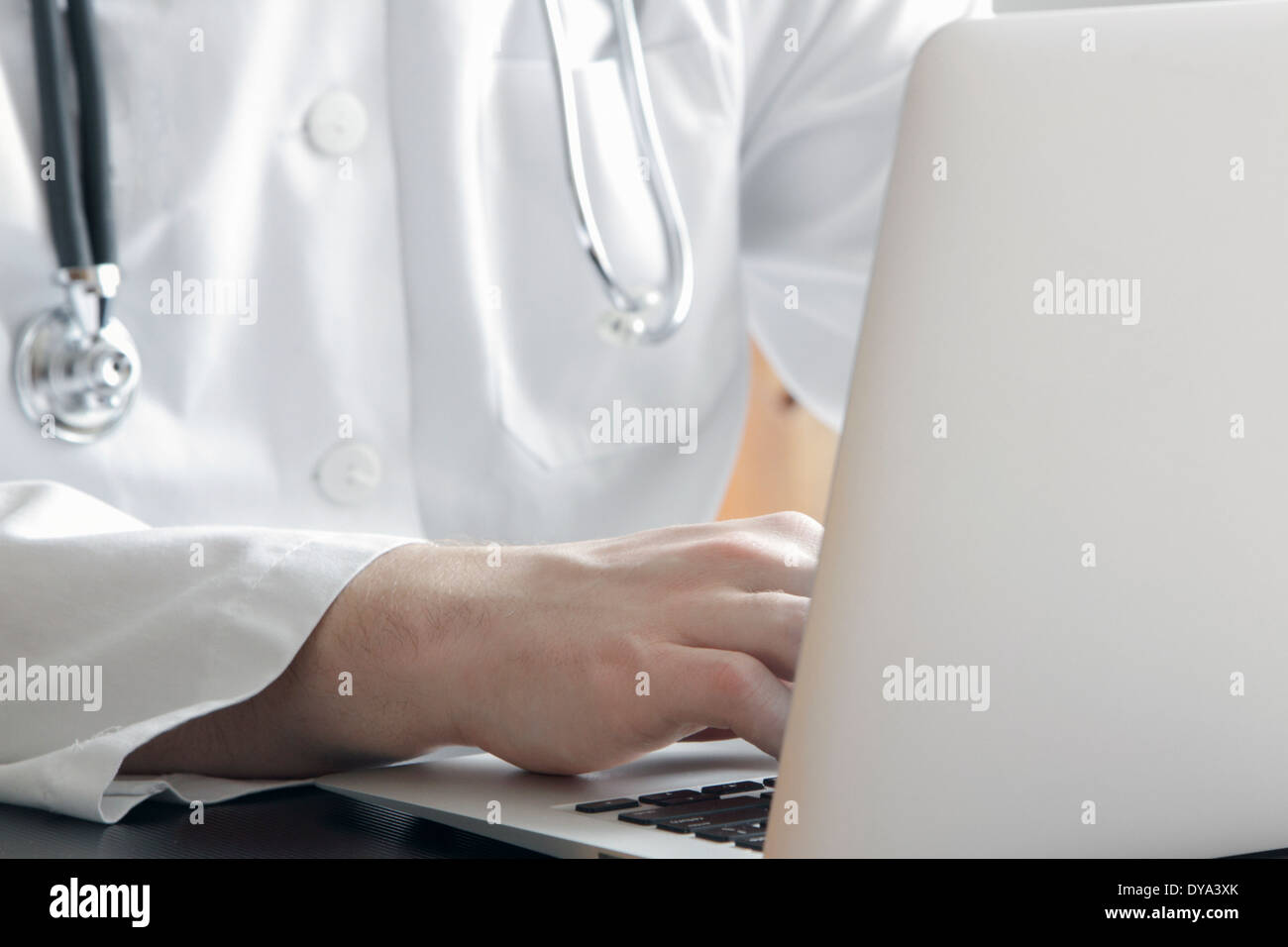 young doctor with white coat and stethoscope with a laptop Stock Photo