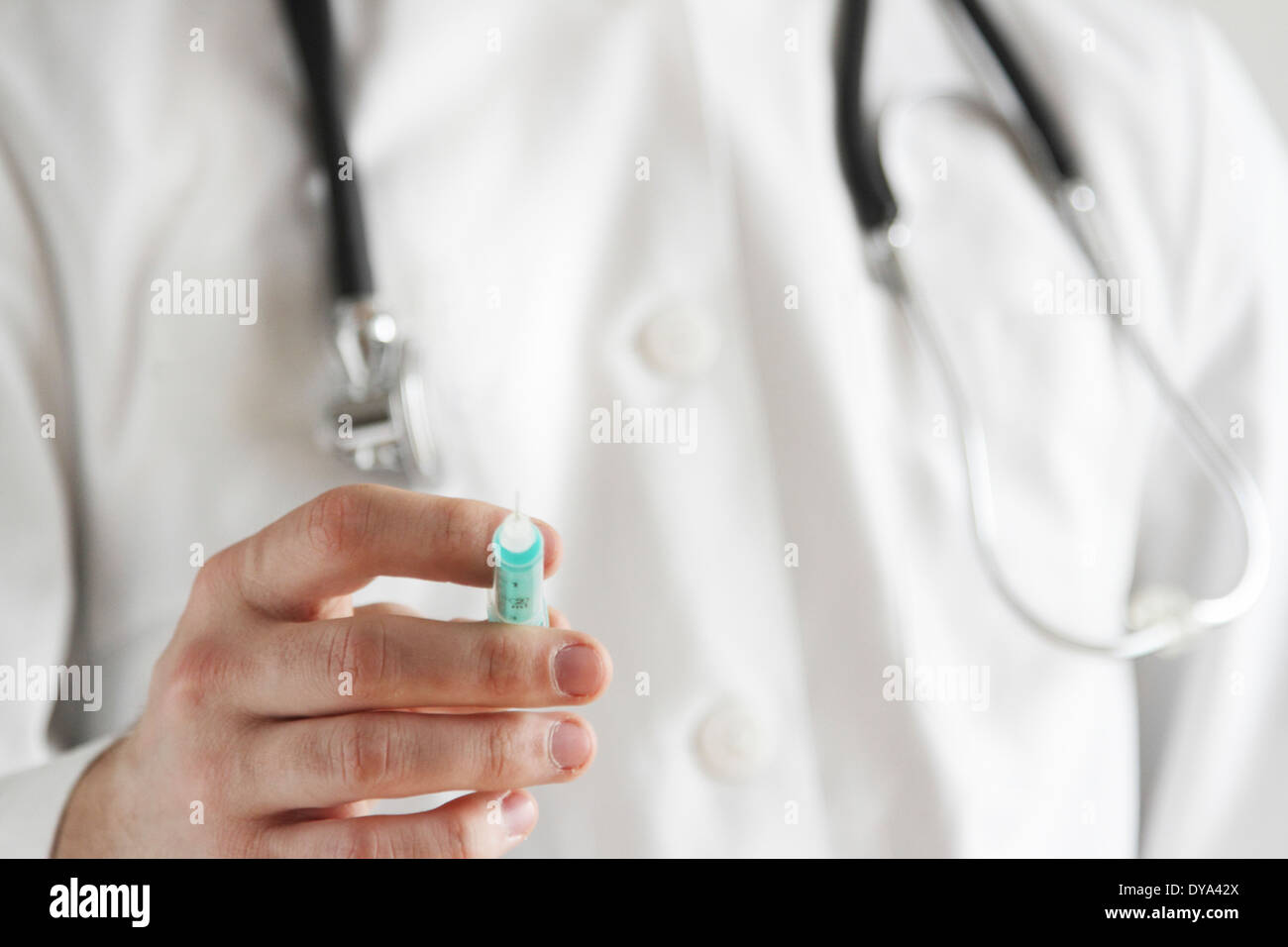 young doctor with white coat and stethoscope wit a syringe Stock Photo