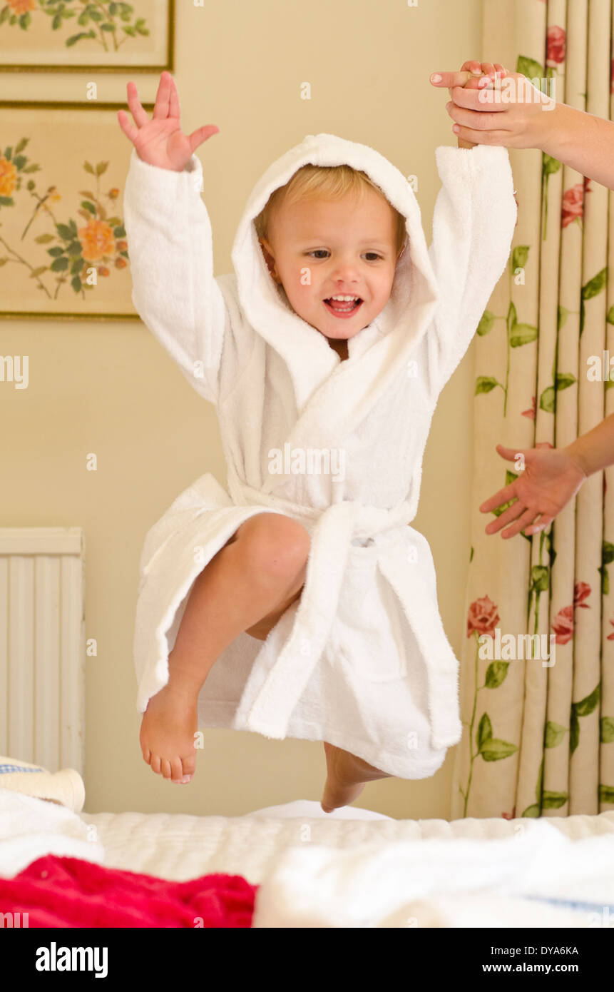 Boy in bathrobe jumping on bed hires stock photography and images Alamy