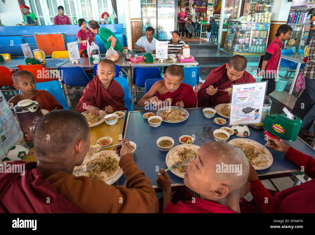 Myanmar, Burma, Asia, Pegu, eating, food, monks, public, restaurant, kids Stock Photo