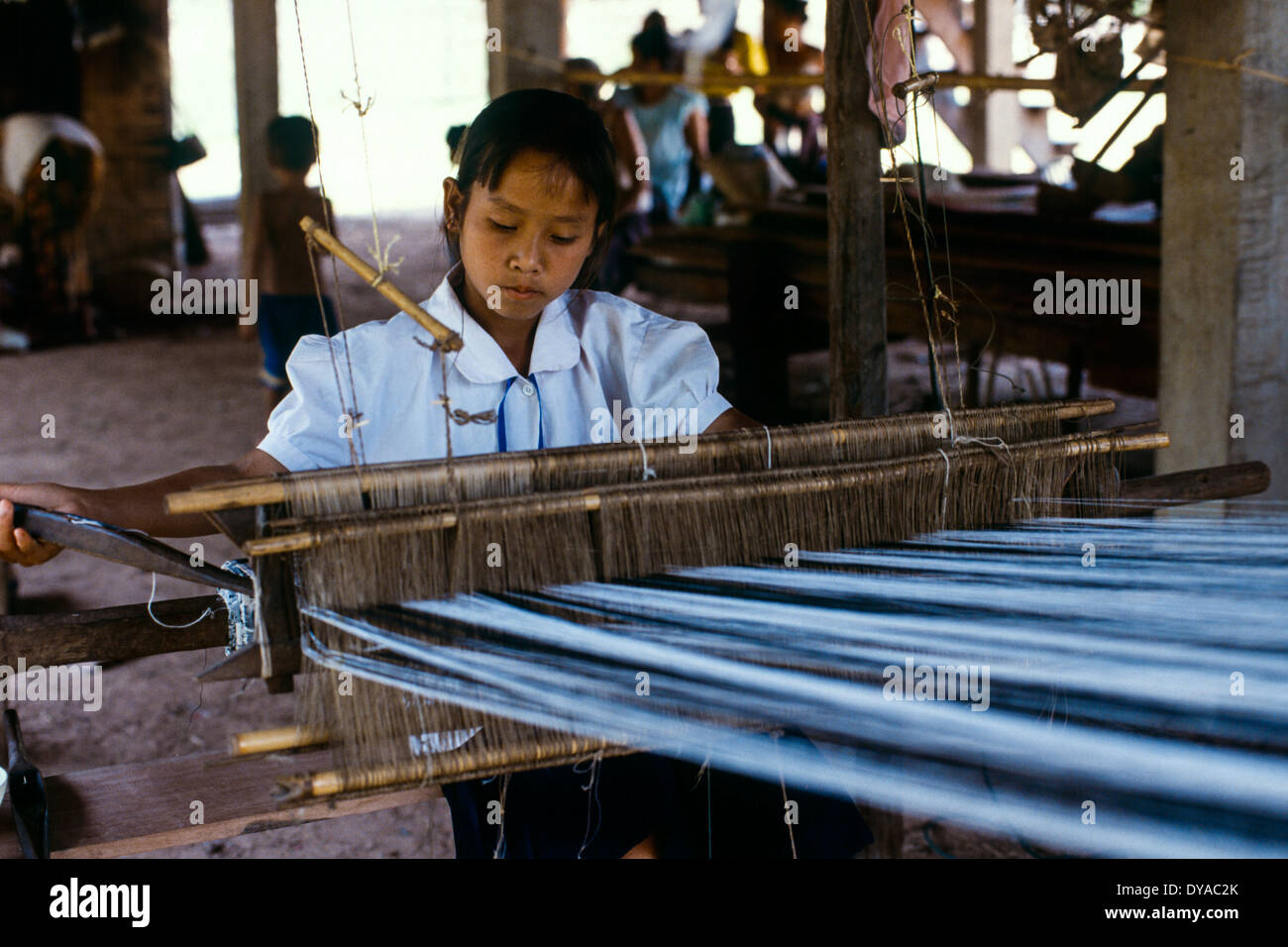 Laos young girl sits weaving peddle loom sunlight shadow community weaver Stock Photo Alamy