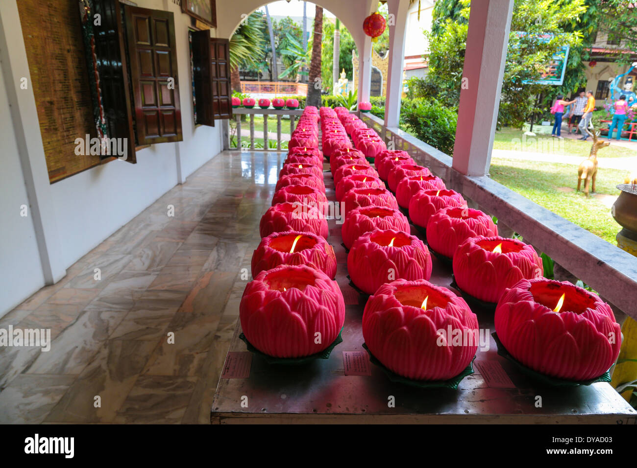 Offering candles donated by devotees at the Dhammikarama, a burmese