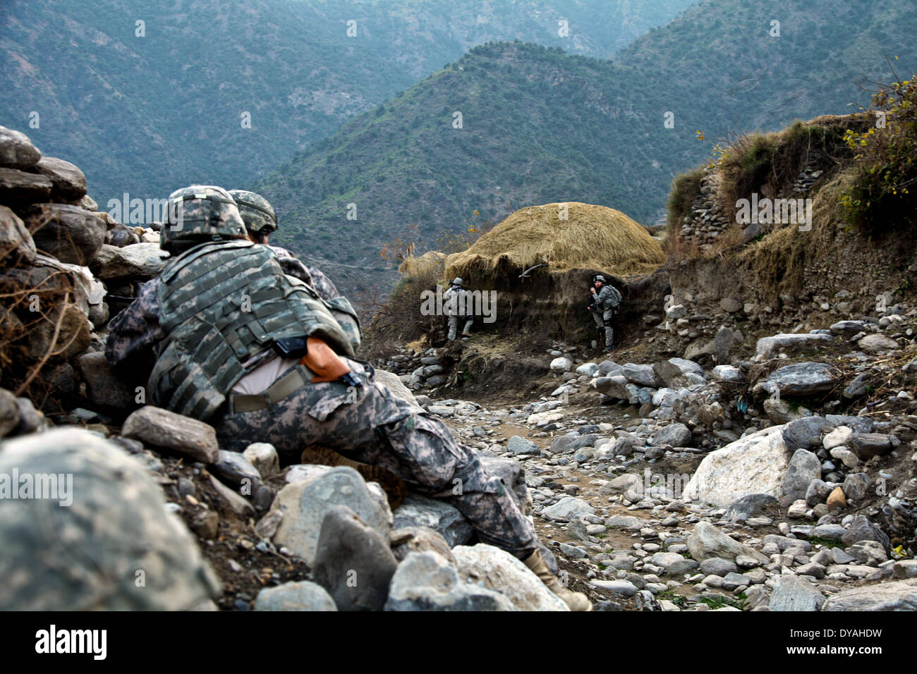 US Army soldiers with the Kunar Provincial Reconstruction Team, take cover during an ambush by Taliban insurgents after holding a shura, or meeting December 7, 2009 in Lachey village, Shigal district, Kunar province, Afghanistan. Stock Photo