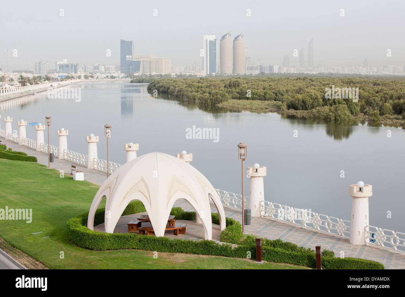 A walkway and park along Al Salam street, and the mangroves with the city of Abu Dhabi in the background. Stock Photo