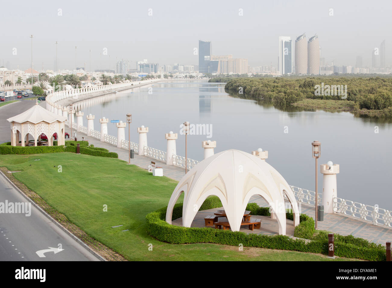 A walkway and park along Al Salam street, and the mangroves with the city of Abu Dhabi in the background. Stock Photo