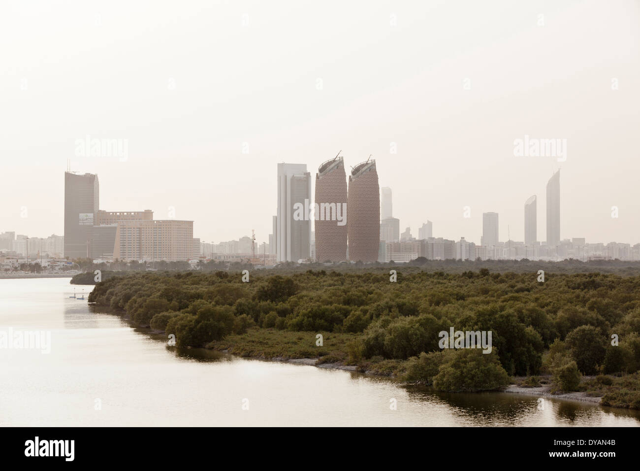 Al Bahar Tower and the city of Abu Dhabi stand above the mangroves, seen from Al Salam Street in Abu Dhabi. Stock Photo