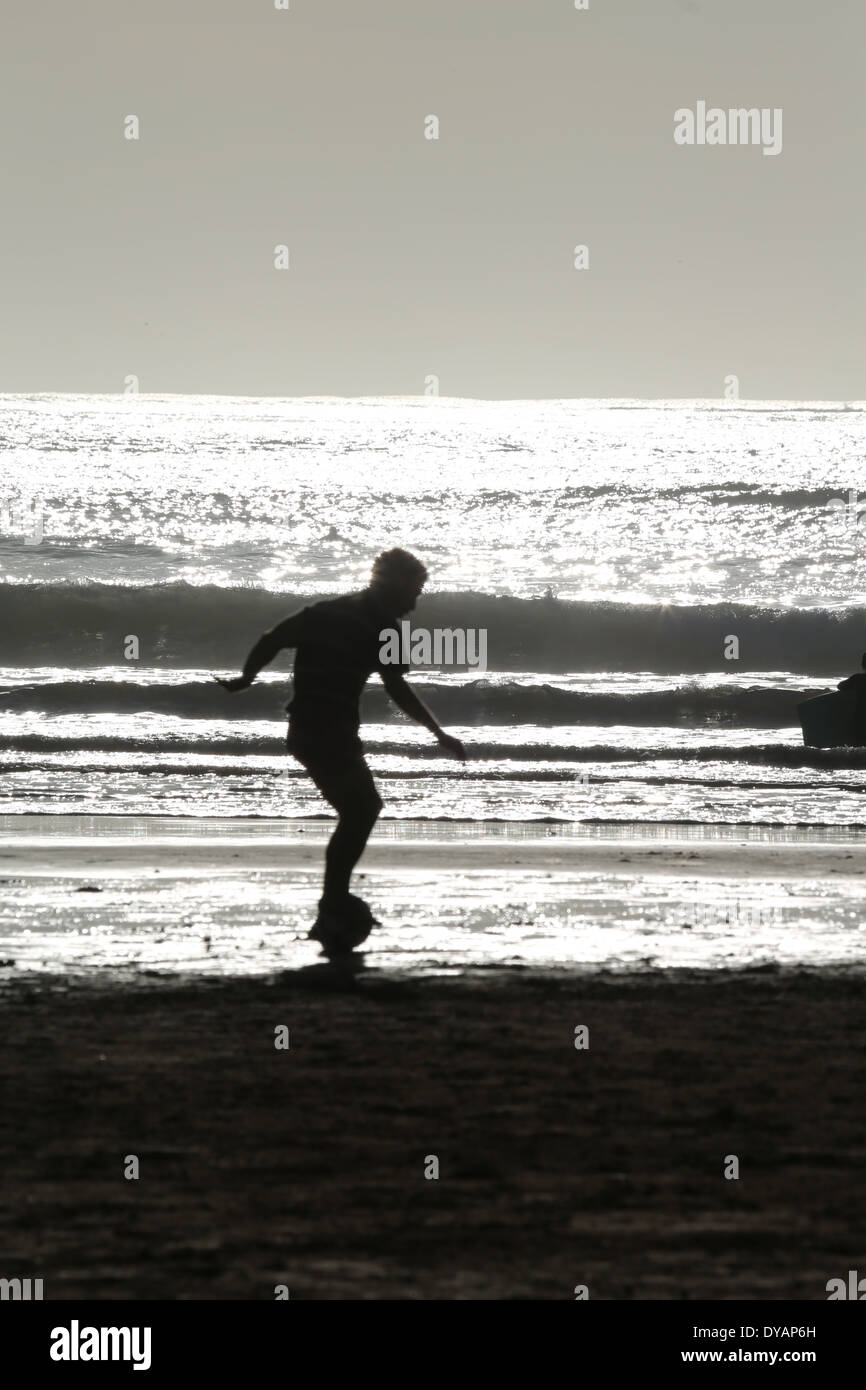 Kids playing football on a beach in Essaouira, Morocco one late evening with the sea illuminated by sunshine (4 of 4) Stock Photo