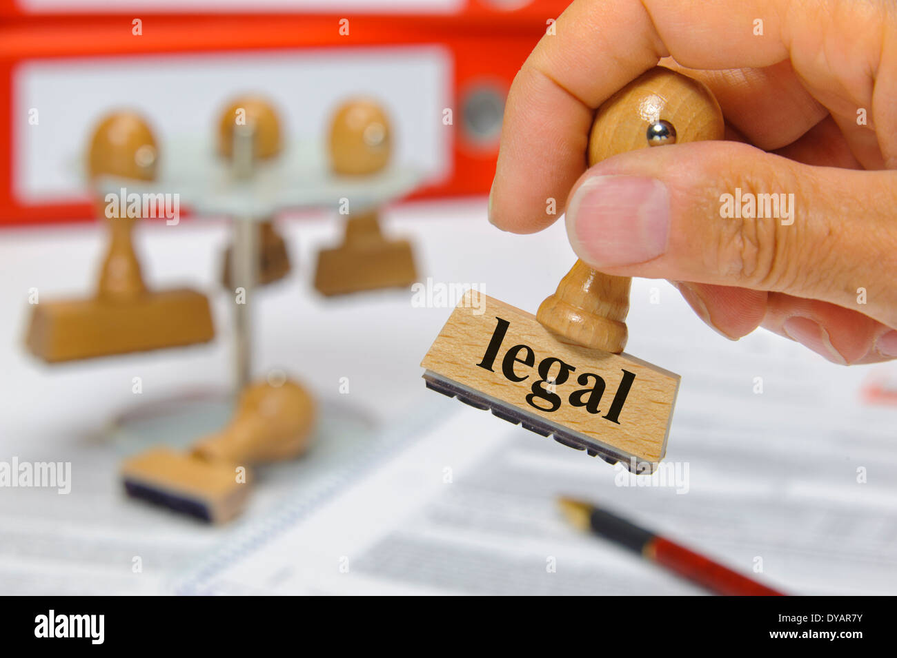 legal marked on rubber stamp in hand Stock Photo