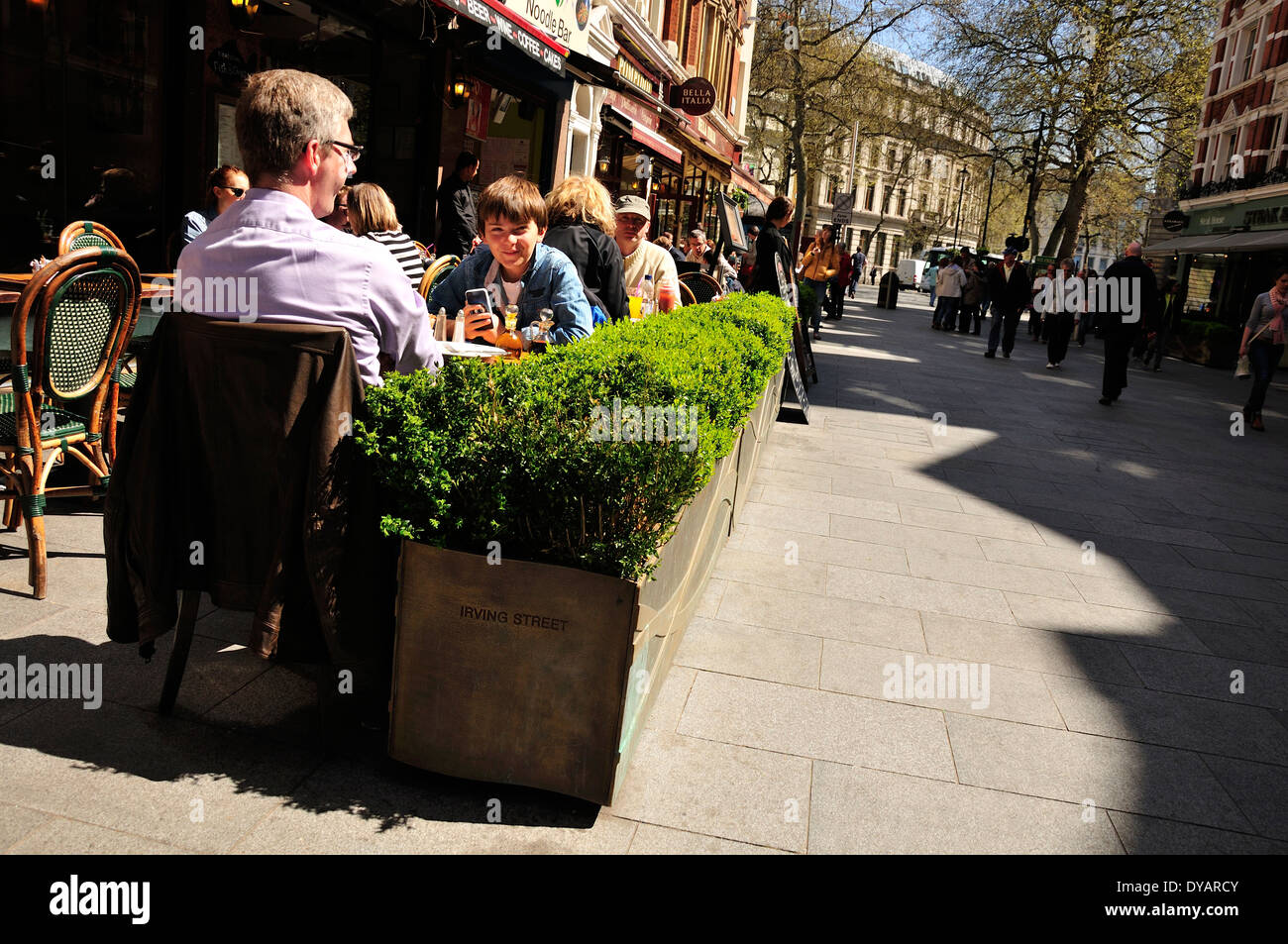 London, England, UK. People eating outside - young boy on mobile phone Stock Photo