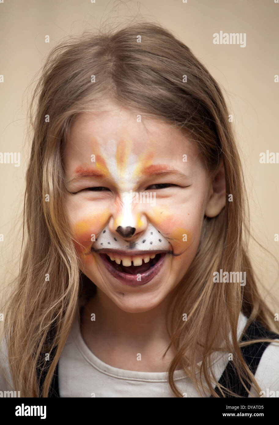 closeup portrait of little girl with cat painting makeup on the face looking at camera Stock Photo