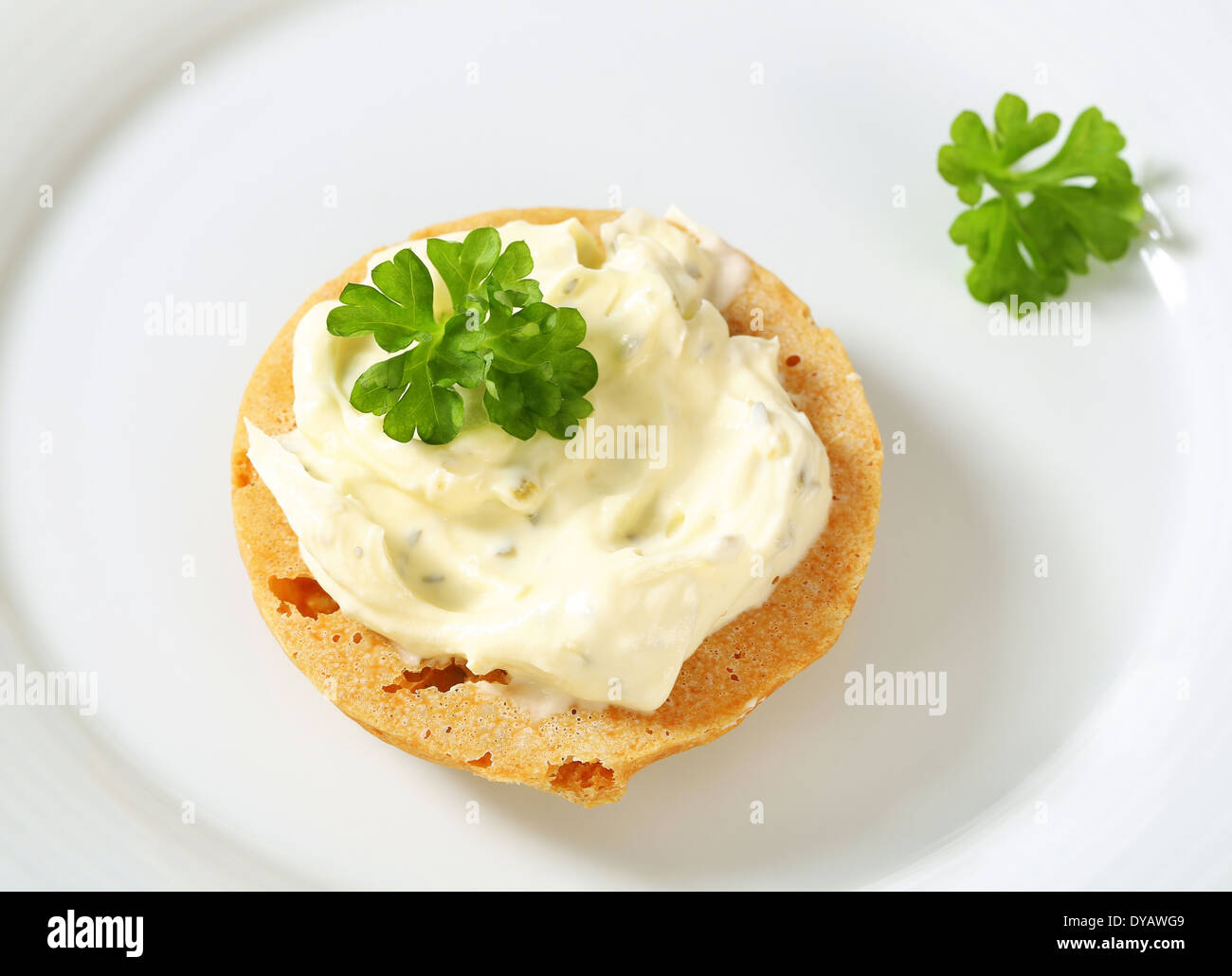 Round cracker with cream cheese spread Stock Photo