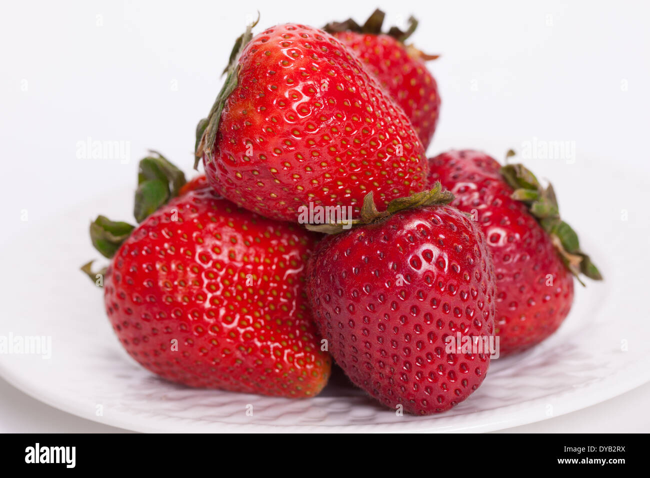 Strawberries in a white plate on white background Stock Photo - Alamy