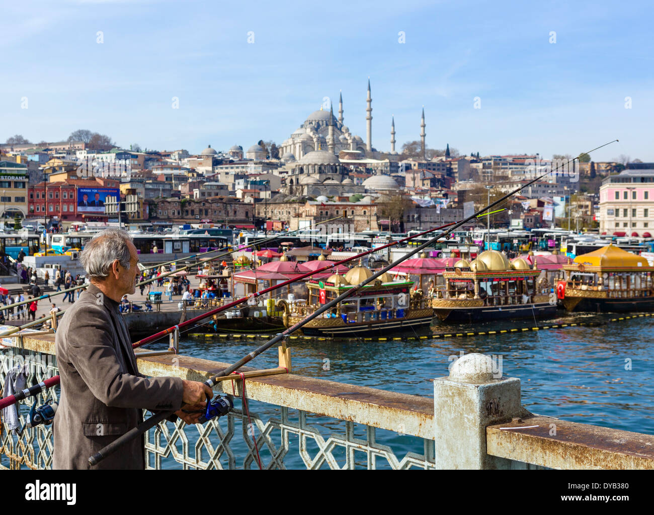 Angler on the Galata Bridge with the Eminonu waterfront behind, Istanbul, Turkey Stock Photo