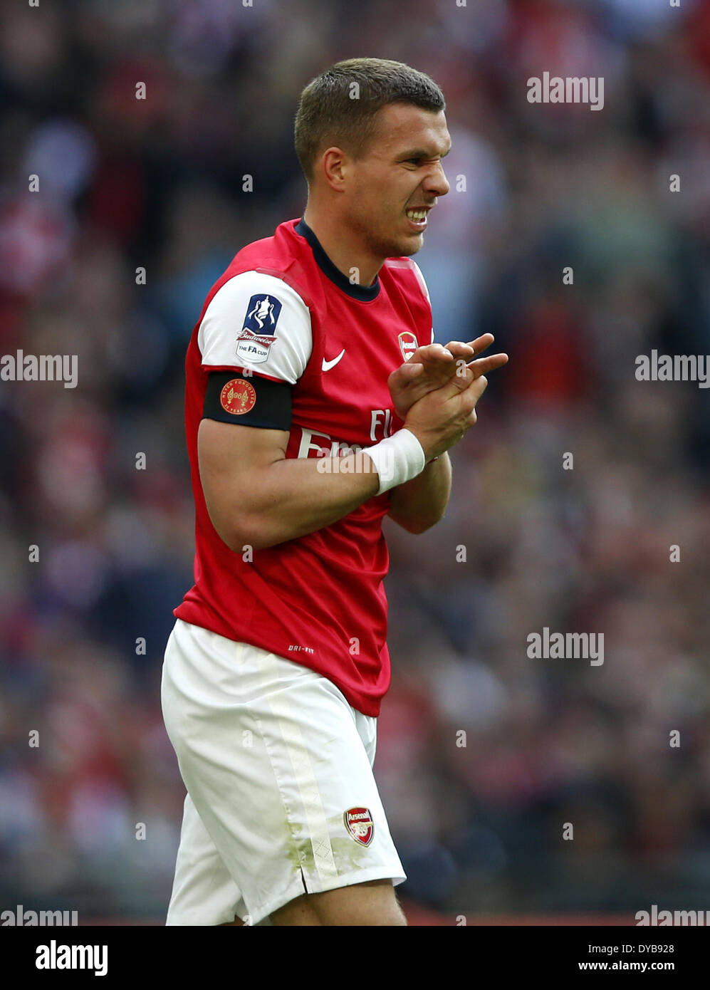 London, Britain. 12th Apr, 2014. Lukas Podolski of Arsenal reacts after injury during FA Cup semifinal match between Arsenal and Wigan Athletic at Wembley Stadium in London, Britain, on April 12, 2014. Arsenal advanced to the final with winning 4-2 on penalties after a 1-1 draw. © Wang Lili/Xinhua/Alamy Live News Stock Photo