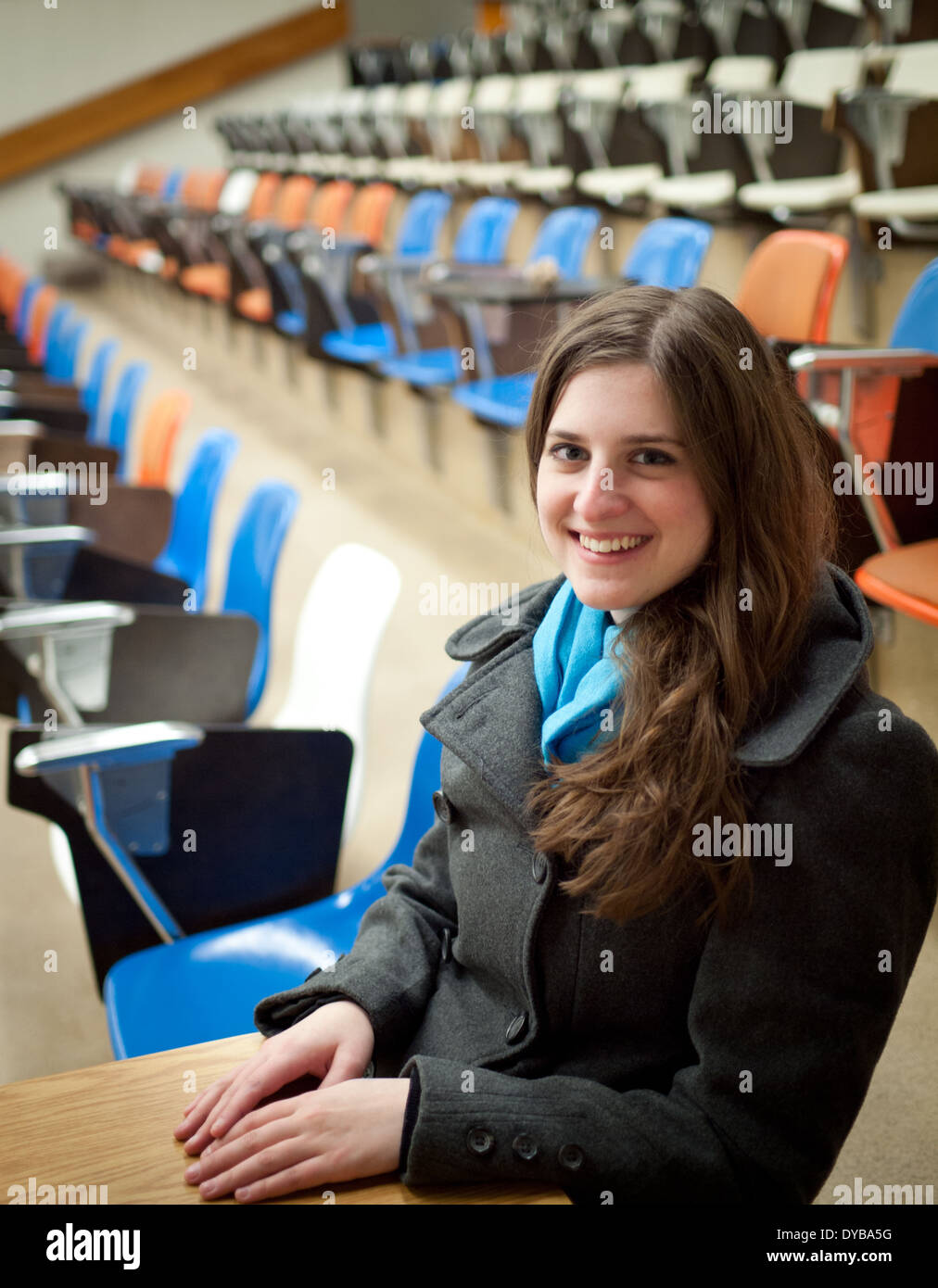 A pretty, brunette university student sits in an empty lecture hall at the University of Alberta in Edmonton, Alberta, Canada. Stock Photo