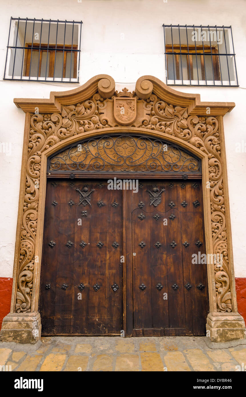 Old wooden door and facade of a white colonial building in San Cristobal de las Casas, Mexico Stock Photo