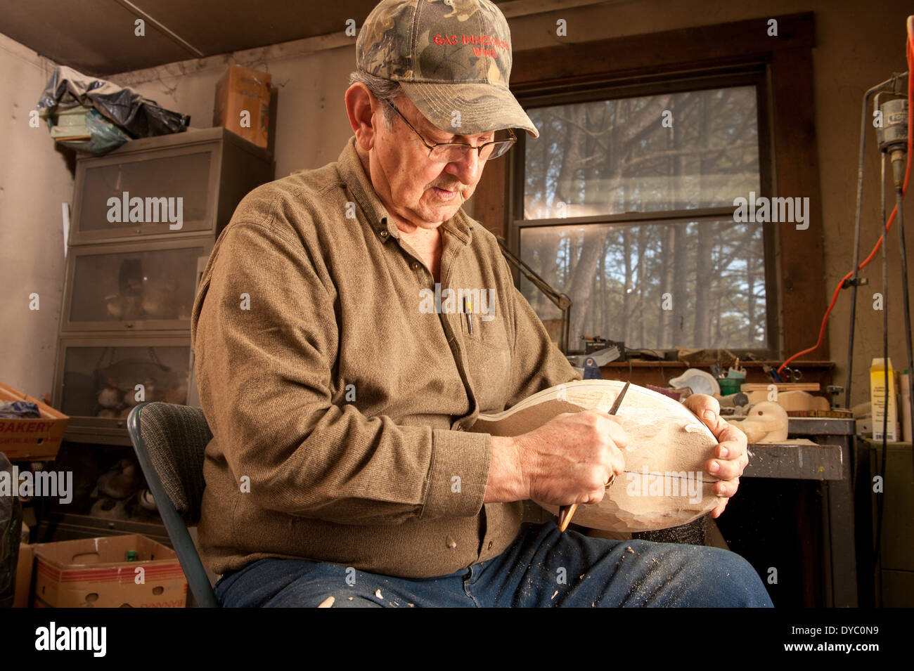 Hand carving a wooden bird decoy Stock Photo