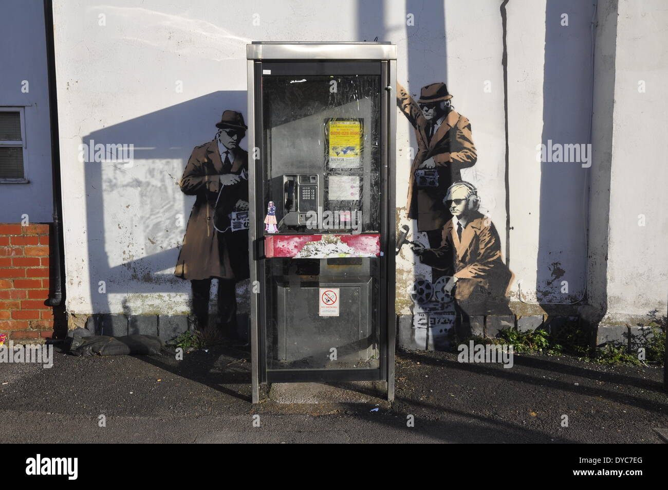 Cheltenham, UK . 14th Apr, 2014. Possible Banksy artwork outside a public telephone box satirising surveillance of citizens' conversations. Credit:  foto-call/Alamy Live News Stock Photo