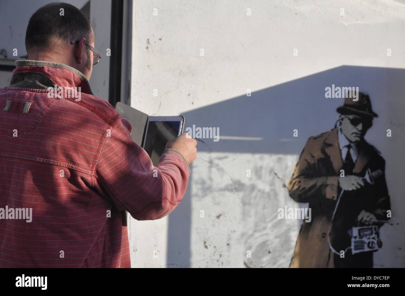 Cheltenham, UK . 14th Apr, 2014. Possible Banksy artwork outside a public telephone box satirising surveillance of citizens' conversations. Credit:  foto-call/Alamy Live News Stock Photo