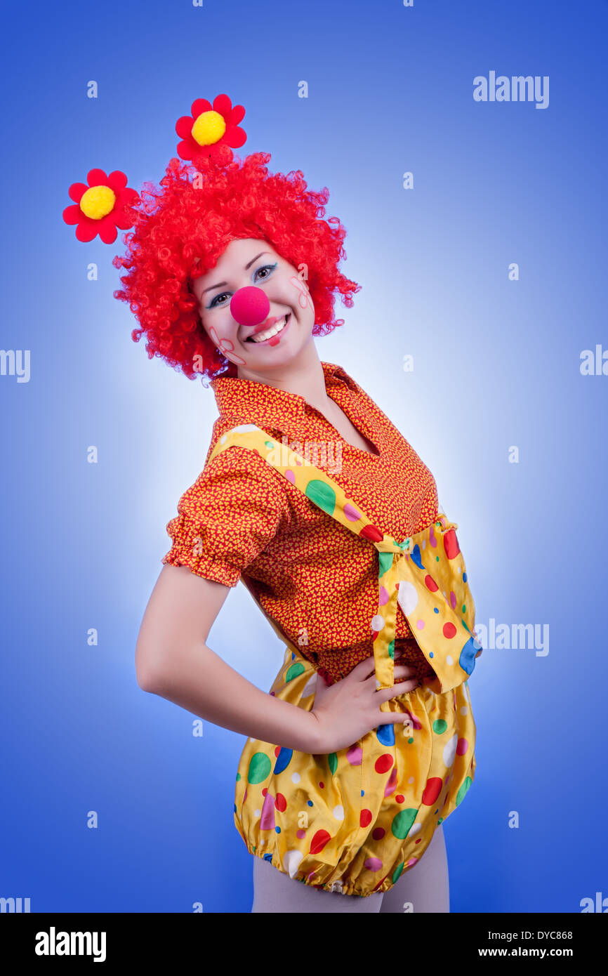 Happy woman clown on blue background. Studio lighting Stock Photo