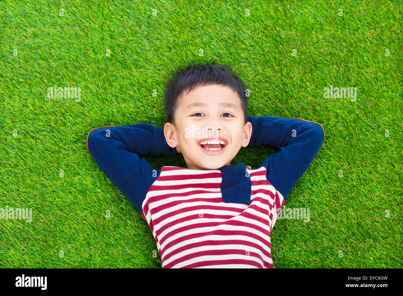 smiling kid lying and holding his head Stock Photo