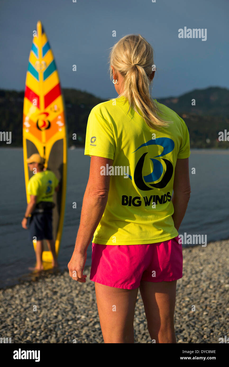 Model release yes MacRae Wylde and Eva DeWolfe getting ready to paddle board on the Columbia River Oregon Hood River USA Summer. Stock Photo