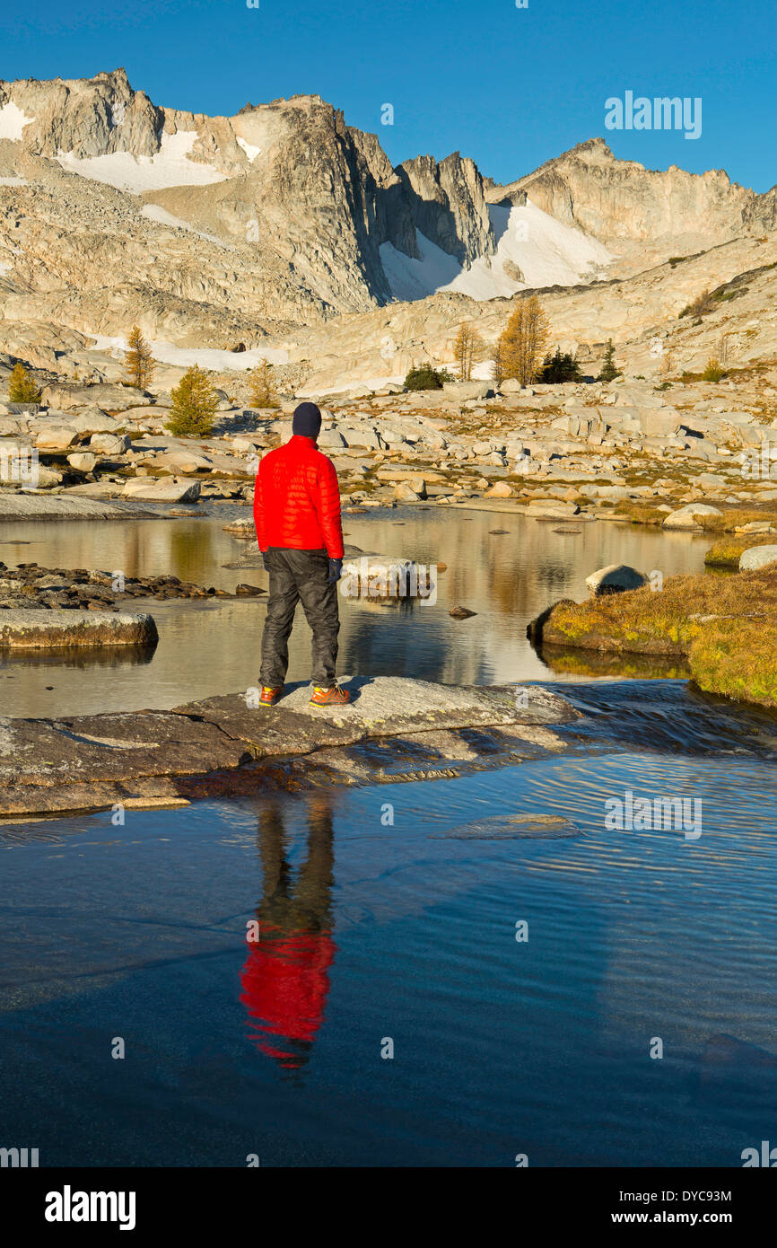 Hiker (Sean Bagshaw) reflects on the route past Dragontail Peaks in the Enchantments section of the Alpine Lakes Wilderness Stock Photo