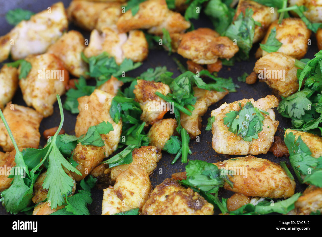 Fried chicken with coriander in frying pan Stock Photo Alamy