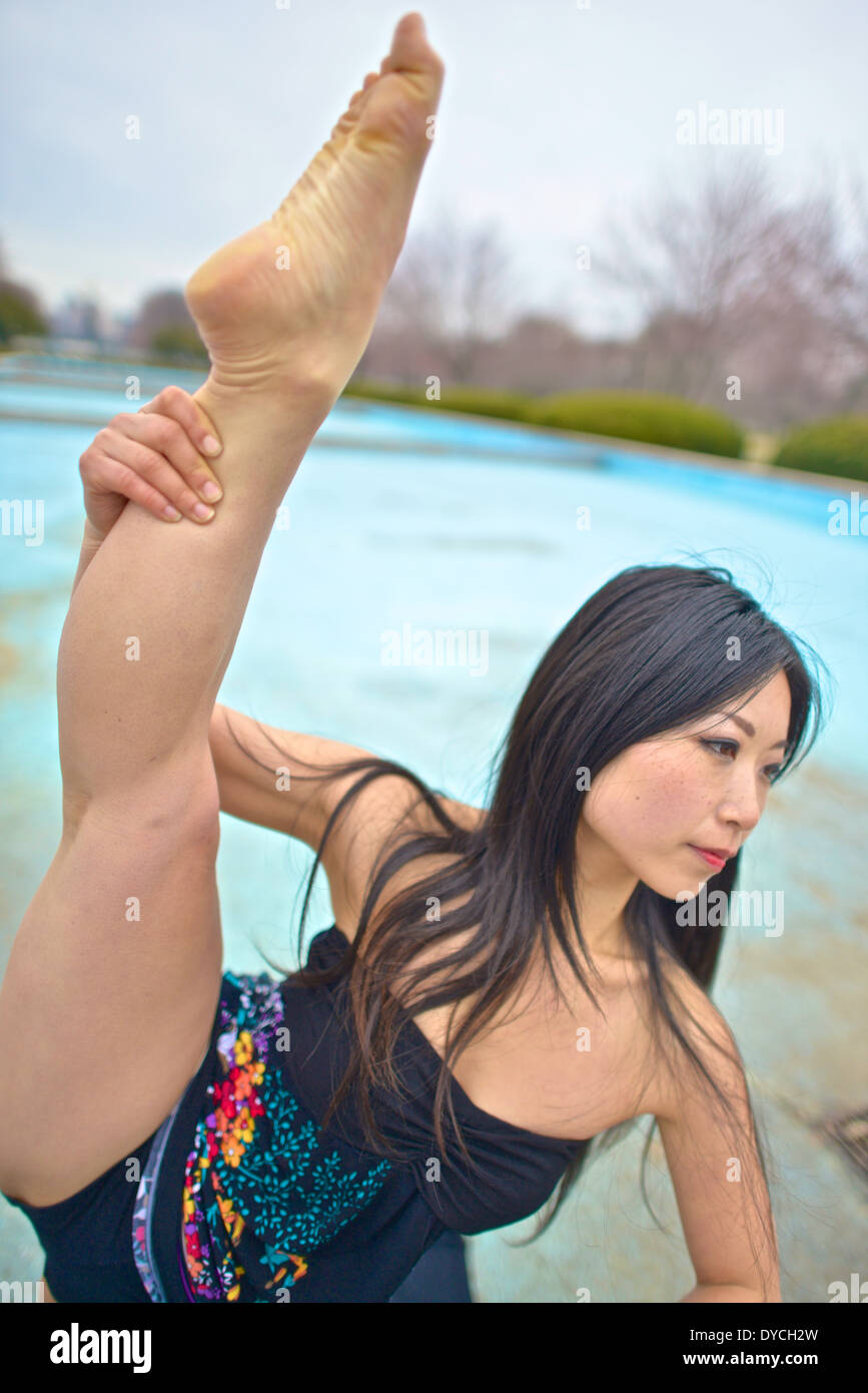 Asian dancer lifting her leg above her head Stock Photo