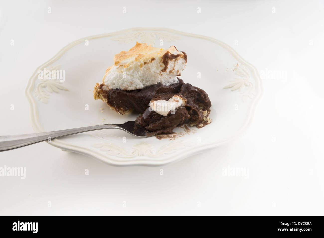 A slice of freshly baked homemade chocolate meringue pie, white background. Stock Photo