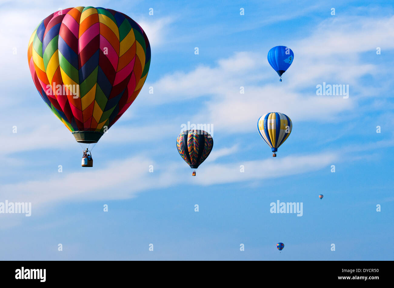 Six hot air balloons rising against a hazy blue sky in Bealeton, Virginia Stock Photo