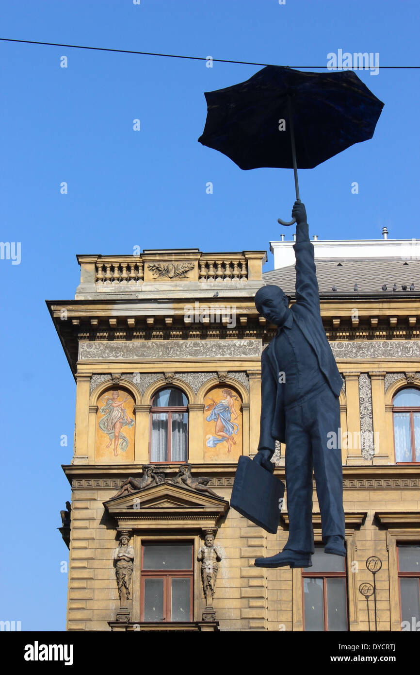 Street sculpture in central Prague; man with umbrella suspended Stock