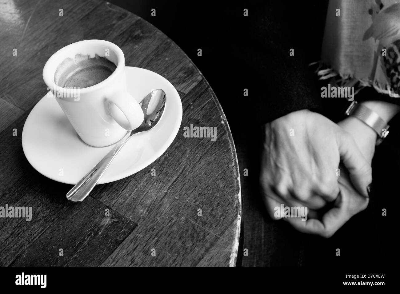 Hands drinking an espresso coffee in a Parisian cafe. Stock Photo