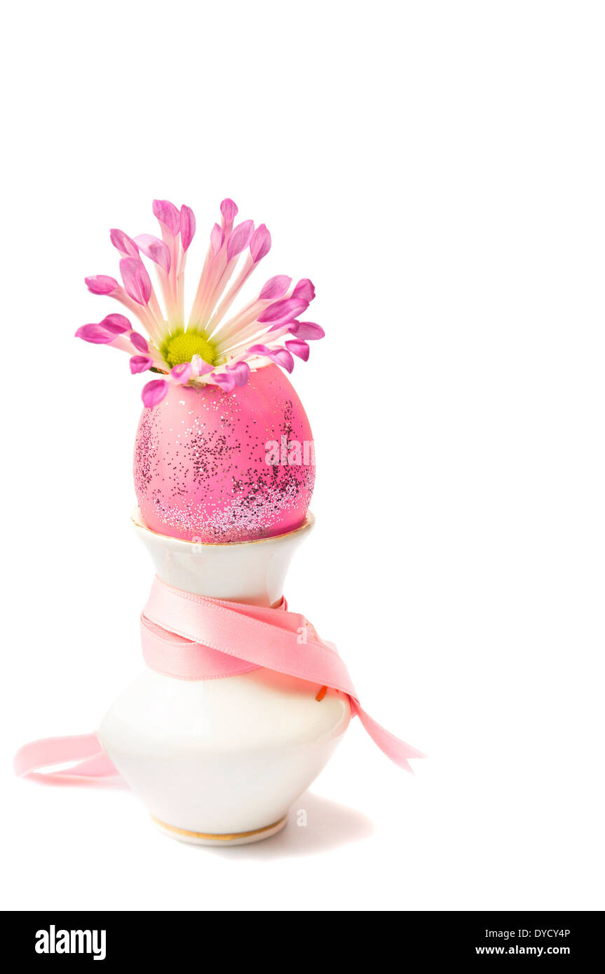 Pink easter egg in mini vase with sprig flower and ribbon on white background Stock Photo