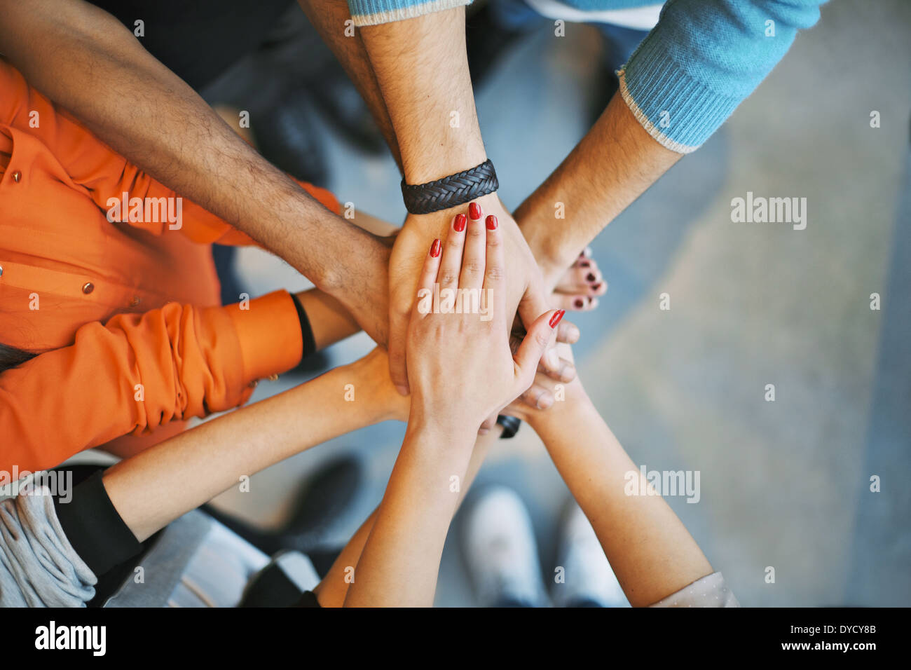 Closeup of stack of hands. Young college students putting their hands on top of each other symbolizing unity and teamwork. Stock Photo