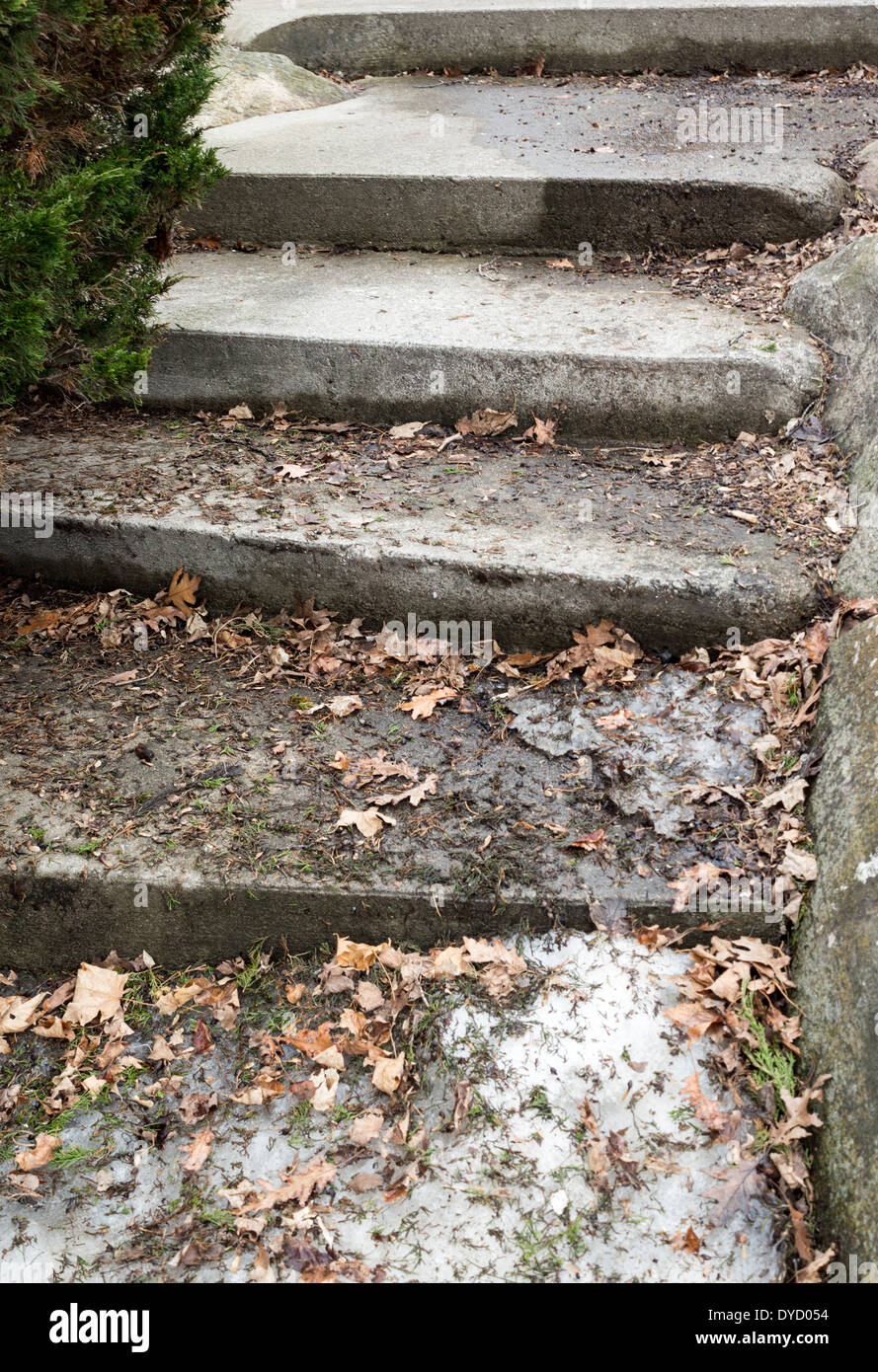 Concrete steps covered in leaves and snow and ice. Stock Photo
