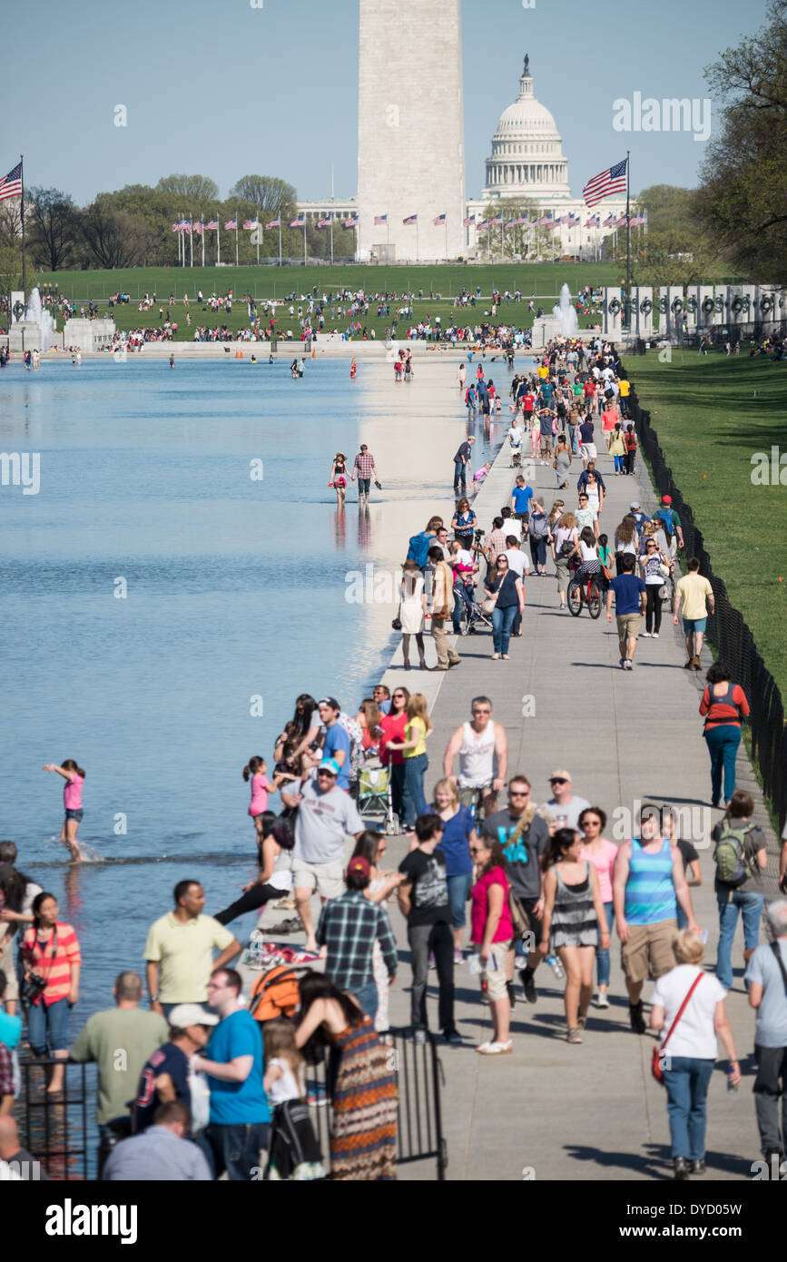 WASHINGTON DC, USA - Visitors take advantage of warm weather to enjoy the newly renovated Lincoln Memorial Reflecting Pool on the National Mall in Washington DC. In the background is the base of the Washington Monument, with the dome of the US Capitol Building in the distance. Stock Photo